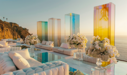 Luxurious sunset lounge with plush sofas, ocean views, and vibrant, reflective pillars.