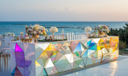 Elegant cocktail bar with geometric design and ocean views, perfect for sunset celebrations.