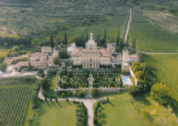 Elegant vineyard estate with mansion, manicured gardens, and picturesque rolling hills.