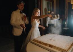 Michelle and Max joyfully celebrate their wedding while cutting a stunning cake.