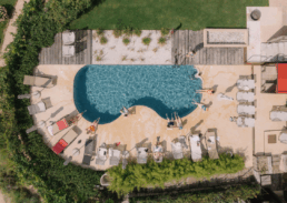 Luxurious poolside scene with vibrant blue water, lounge chairs, and lush greenery for relaxation.